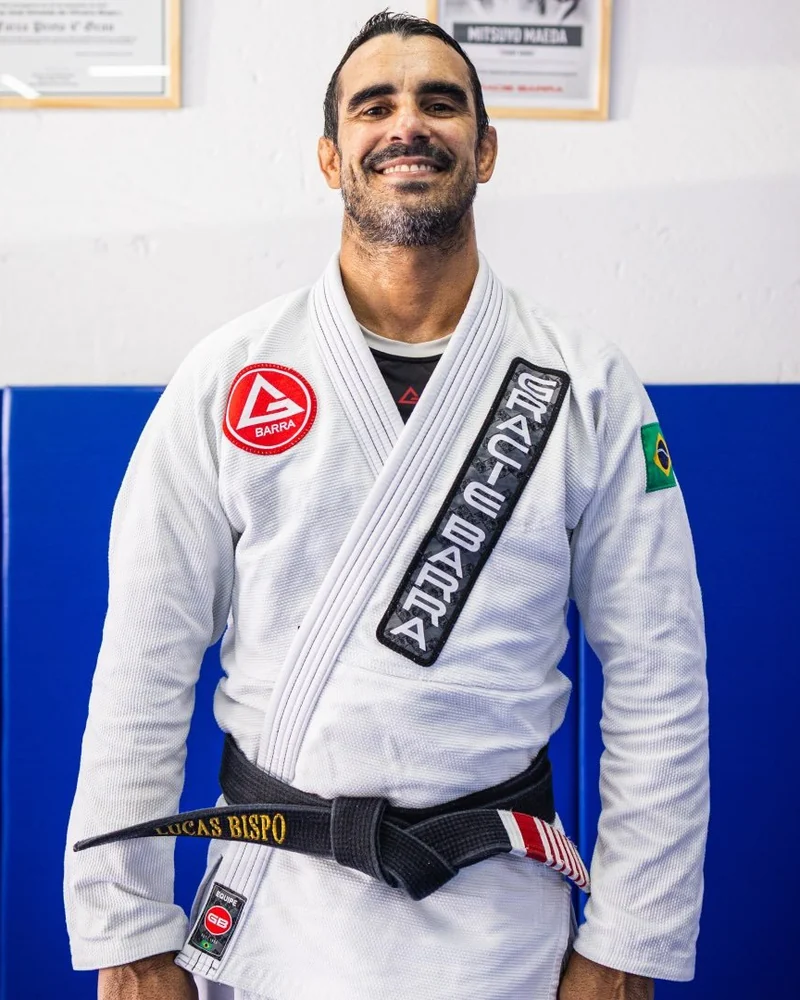 Professor Lucas Bispo sorrindo, de kimono Gracie Barra